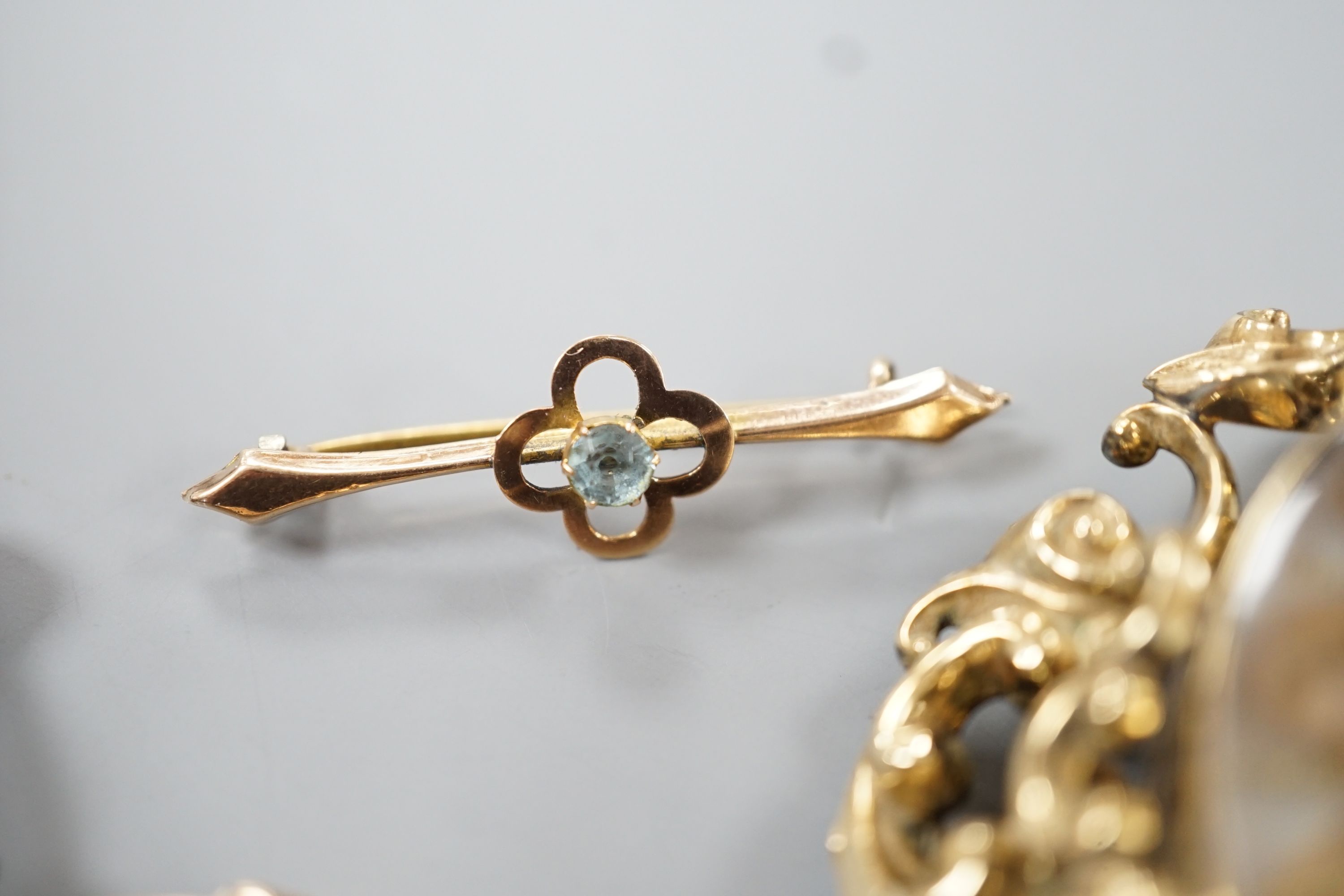 A Victorian yellow metal mounted plaited hair mourning brooch, 6cm, a yellow metal mounted magnifying glass, a similar stick pin and eye glass and a 9ct and gem set bar brooch.